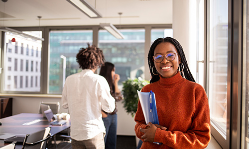 Jeune fille avec livre dans la main, elle nous regarde en souriant, studieuse
